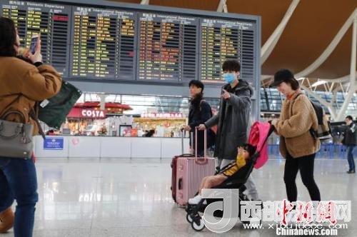 旅客帶著孩子前往辦票柜臺(tái)辦理登機(jī)手續(xù)?！∫罅⑶?攝