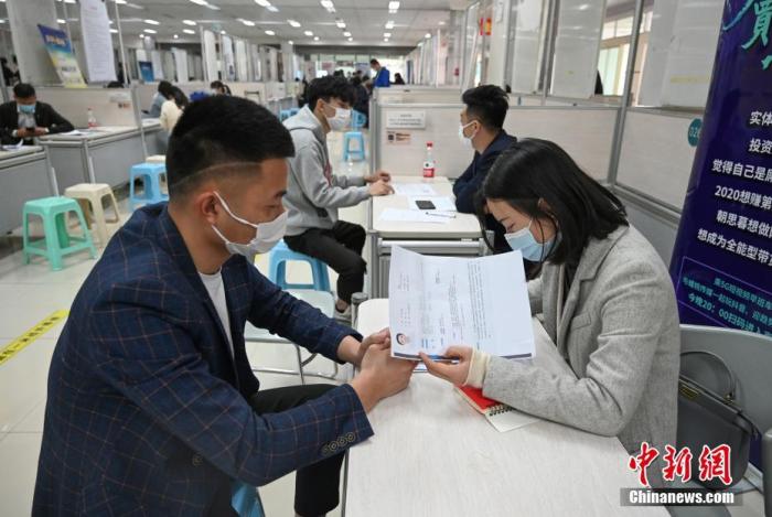 4月14日，招聘者在查看求職者簡(jiǎn)歷。<a target='_blank'  data-cke-saved- >中新社</a>記者 王剛 攝