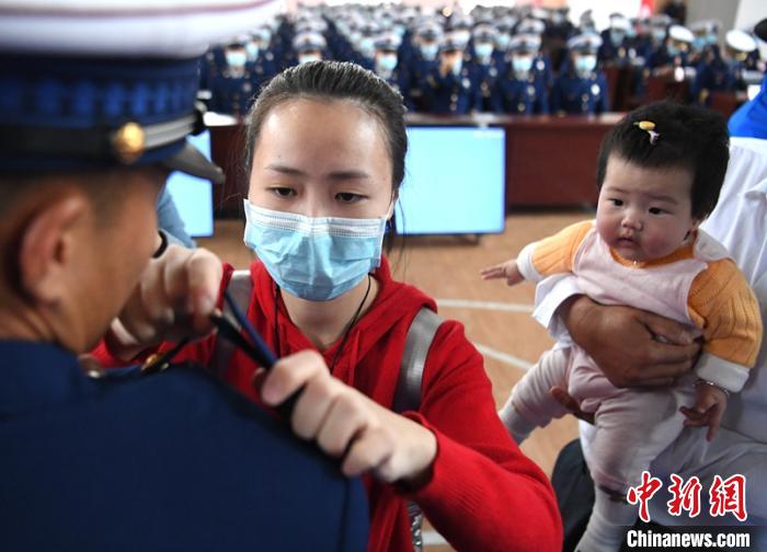 新消防員楊振的妻子彭莉與女兒現(xiàn)場見證丈夫加入“火焰藍(lán)”的神圣時刻?！⒅铱?攝