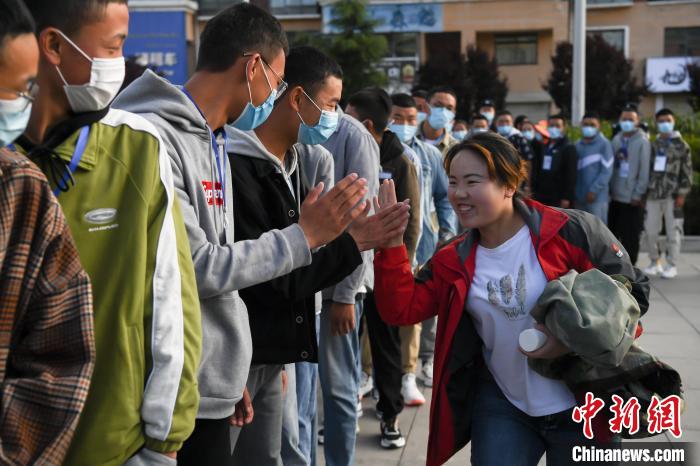 7月7日，拉薩三高考點外，領(lǐng)隊老師與考生擊掌鼓勁加油?！『闻罾?攝