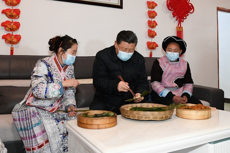 2021年2月3日下午，習(xí)近平在貴州畢節(jié)市黔西縣新仁苗族鄉(xiāng)化屋村苗族村民趙玉學(xué)家，同一家人邊聊家常邊制作當(dāng)?shù)貍鹘y(tǒng)節(jié)日食品黃粑。新華社記者 李學(xué)仁 攝